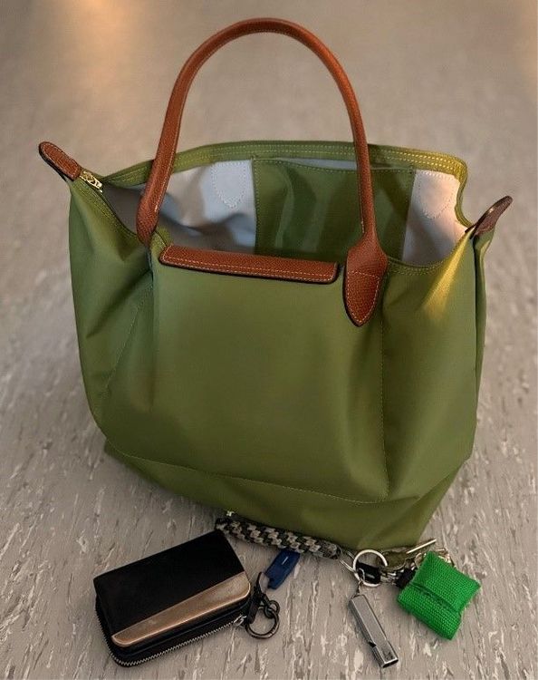 Grüne Handtasche mit davor liegendem Schlüsselbund und Portemonnaie